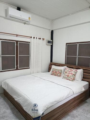 Ban Pong Nuaไร่ดง โฮมเสตย์的卧室配有一张带白色床单和枕头的大床。