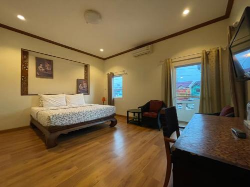 Ban Bo HanGuesthouse Phuket Airport的一间卧室配有一张床、一张桌子和一台电视