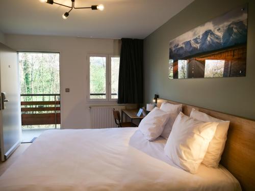 勒·维威恩斯·杜·拉克Motel 991的一间卧室配有带白色床单和枕头的床。