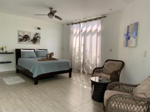 萨玛拉Las Perlitas Rentals Playa Samara的一间卧室配有一张床、一张沙发和一把椅子