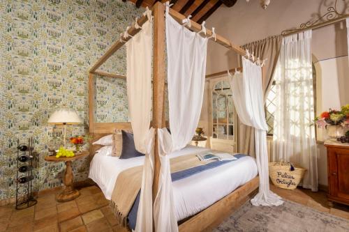 蒙特普齐亚诺黎莱斯奥塔丽亚酒店的一间卧室,卧室内配有一张天蓬床