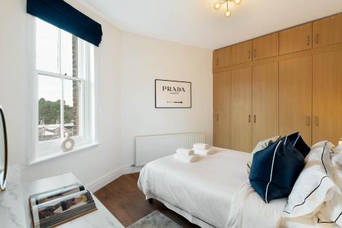 伦敦Luxury Chelsea Flat的白色的卧室设有床和窗户