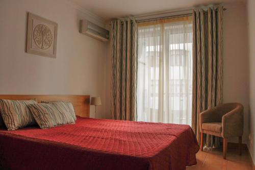 蒙蒂戈杜Monte da Praia的一间卧室设有红色的床和窗户。