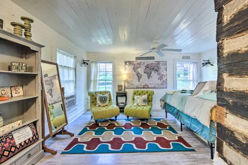 马绍尔Historic Marshall Log Cabin Less Than 1 Mi to Dtwn!的一间卧室配有一张床和两把椅子