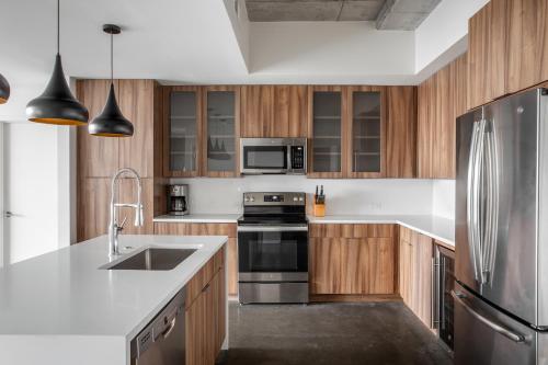 奥斯汀Kasa 2nd Street Austin的厨房配有木制橱柜和不锈钢冰箱。