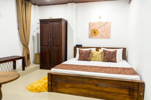 尼甘布Cinnamon Tan Boutique Hotel的一间卧室配有一张木架大床