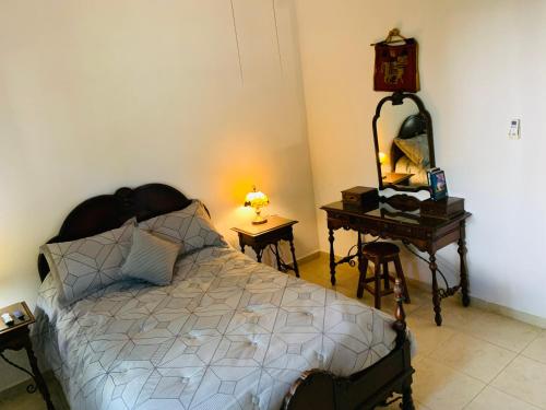 普拉亚卡门La Casa de Leo Recamara 1 Villa Cardiell QROO的一间卧室配有一张床和一张带镜子的桌子