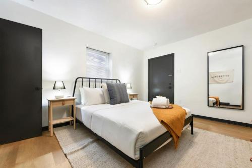 匹兹堡HostWise Stays - Pet Friendly Butler St Apt, Ground Floor with Private Entrance的一间卧室配有一张大床和镜子