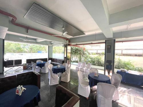 那格浦尔HOTEL AIRPORT KK的一间设有蓝色桌子和白色椅子的餐厅