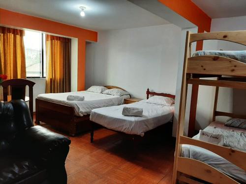 阿亚库乔Hostal Don Cristobal的客房设有两张双层床和一张沙发。