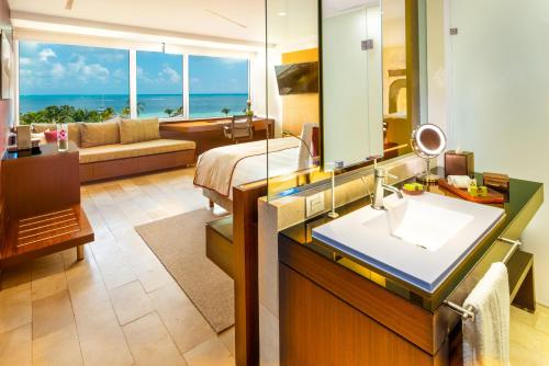 坎昆InterContinental Presidente Cancun Resort的浴室设有床、水槽和镜子