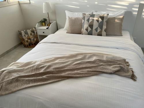 里雄莱锡安Lux & Comfy ~ Pool ~ Queen Beds的一条毯子躺在卧室的床上