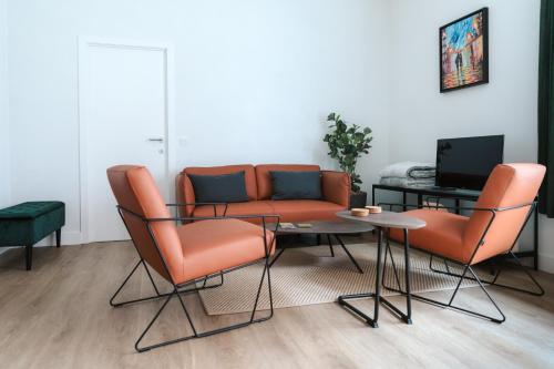 根特城市公寓的客厅配有橙色椅子、桌子和沙发
