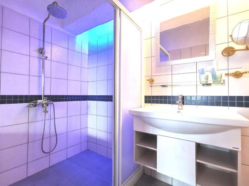 鹅銮鼻家欧风海景民宿 的紫色浴室设有水槽和淋浴