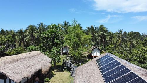 San MiguelBinga Beach Palawan Glamping的一组拥有太阳能电池板和棕榈树的房屋