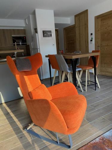 圣沙夫雷LE DOUX MELEZE的客厅配有橙色椅子和桌子