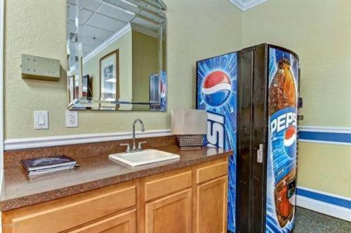 杰克逊维尔Cozy Downtown One Bedroom Condo Jacksonville的浴室设有水槽旁的百事可乐冰箱
