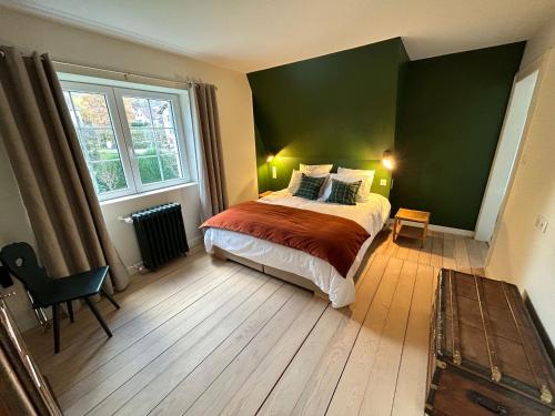 巴尔Le Hêtre Rouge Charme & Spa的一间卧室设有一张床和绿色的墙壁