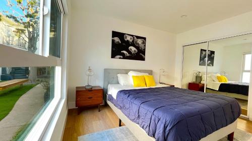 洛杉矶Kingsley Courtyard Apartment的一间卧室设有一张床和一个大窗户