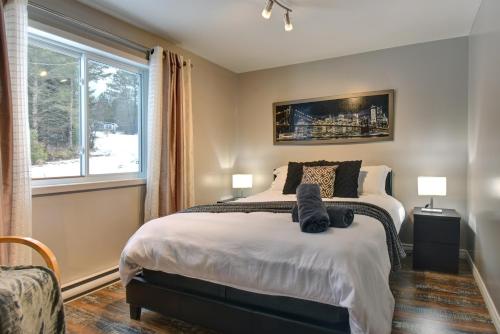 Rivière-RougeSheldon Enchanting on Lake Cottage with Jacuzzi的一间卧室设有一张大床和一个窗户。