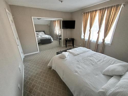 布法罗Cozy Updated 3-BR apartment near Peace Bridge的卧室配有一张白色大床和镜子