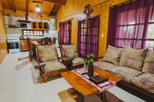 伊瓜苏港Cabañas Riberas del Paraná的客厅配有沙发、椅子和桌子