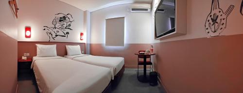 日惹Kotta GO Yogyakarta的一间酒店客房,设有两张床和电视