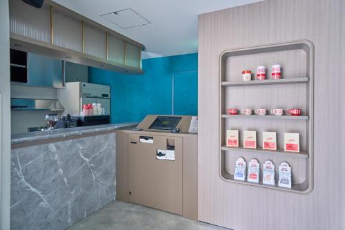 东京FAV TOKYO Nishinippori的厨房配有柜台和带奶瓶的冰箱