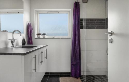 凯特明讷2 Bedroom Nice Home In Kerteminde的浴室配有水槽和带紫色窗帘的淋浴