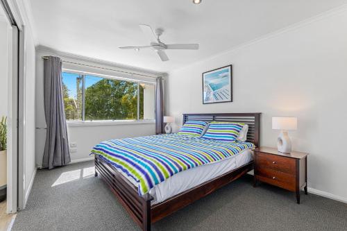 纳鲁马Unit 6 Boardwalk Apartment的一间卧室设有一张床和一个窗口