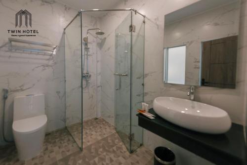 贡布Twin Hotel的一间带水槽和玻璃淋浴的浴室