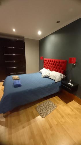 贝伦Casa de campo的一间卧室配有一张大床和红色床头板