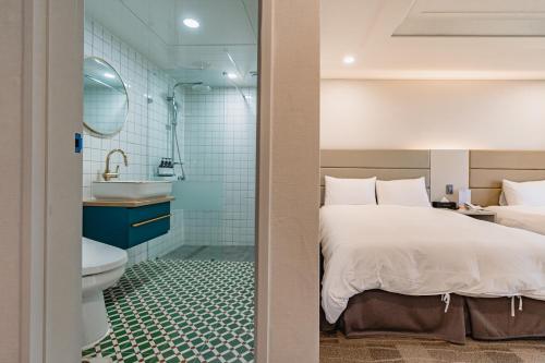 济州市Cocoon Hotel的一间卧室配有一张床,浴室设有水槽