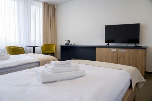 特雷比绍夫Wellness hotel Mestská plaváreň的酒店客房设有两张床和一台平面电视。