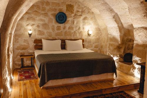 格雷梅Hanzade Cappadocia的石头间内一间卧室,配有一张床