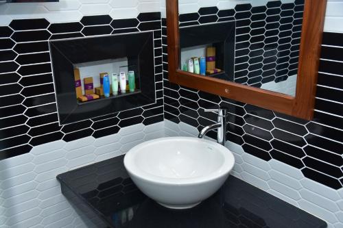 丹不拉Eden Grand的浴室设有白色水槽和镜子