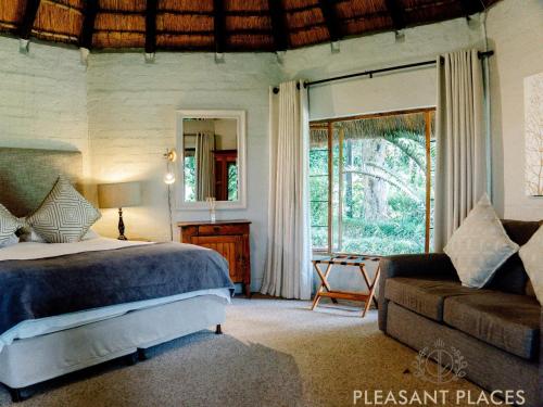 LidgettonPleasant Places By Sanaandi的一间卧室配有一张床、一张沙发和一个窗口