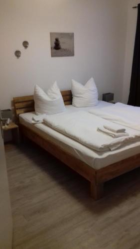 岑平Strandidyll的一间卧室配有带白色床单和枕头的床。