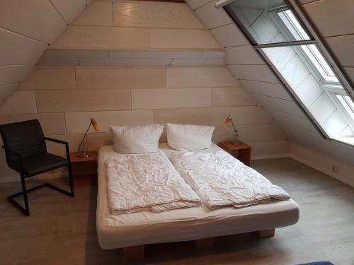 普特布斯"Blick auf Vilm", Neuendorf的阁楼卧室配有床和椅子