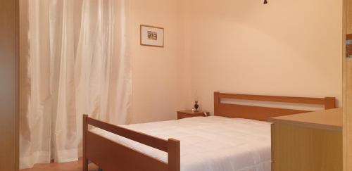 科米索Bellona 319的一间卧室配有一张带白色床单的床和一扇窗户。
