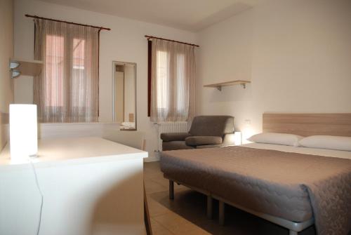 马格拉Hotel Lugano Torretta的一间卧室配有一张床、一张沙发和一把椅子