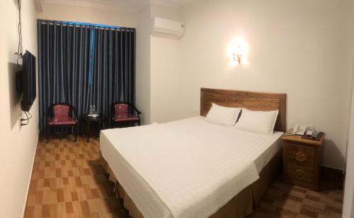 荣市Trường Thịnh Hotel的一间卧室配有一张大床和电视