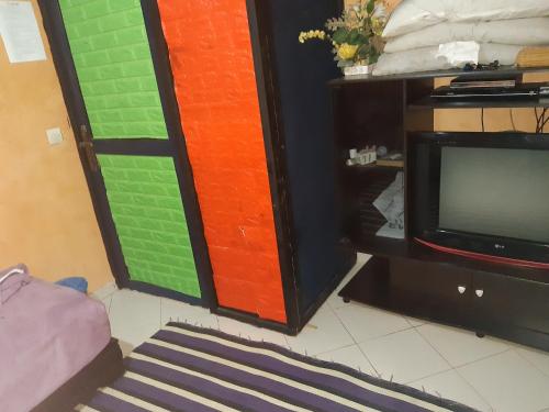 卡萨布兰卡Appartement Aznavour的客房设有电视和色彩缤纷的墙壁。