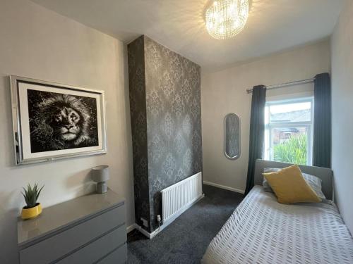 PembertonModa House Wigan - Beautiful 4 Bed Property的卧室配有一张床,墙上挂着一幅画