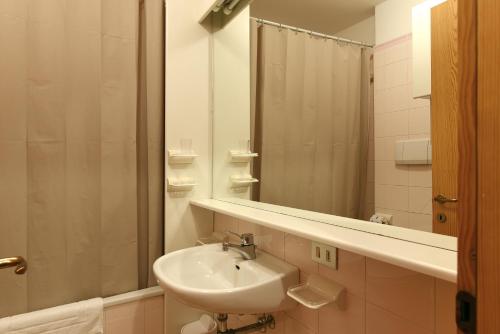 圣克里斯蒂娜Residence Hotel Casa Metz的一间带水槽和镜子的浴室