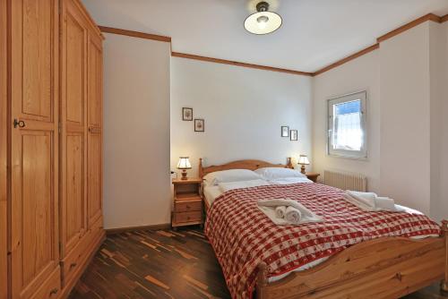 圣克里斯蒂娜Residence Hotel Casa Metz的一间卧室配有一张带红色毯子的大床