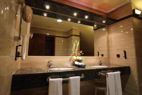 巴利亚多利德Hotel Conde Ansúrez的一间带两个盥洗盆和大镜子的浴室