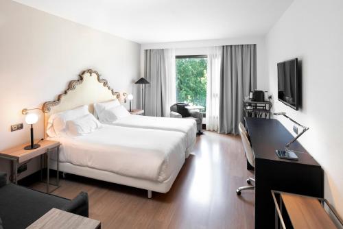 阿维莱斯帕拉西奥阿维莱斯NH收藏酒店的酒店客房设有一张白色大床和一张书桌
