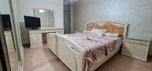 开罗Comfy 2-Bedrooms Apartment in Cairo 44-2的一间卧室配有一张床和一台电视