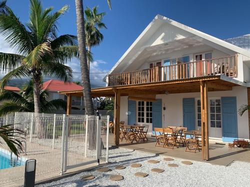 埃唐萨莱莱班海滩LE NID TROPICAL的海滩上的房子,配有甲板和桌子
